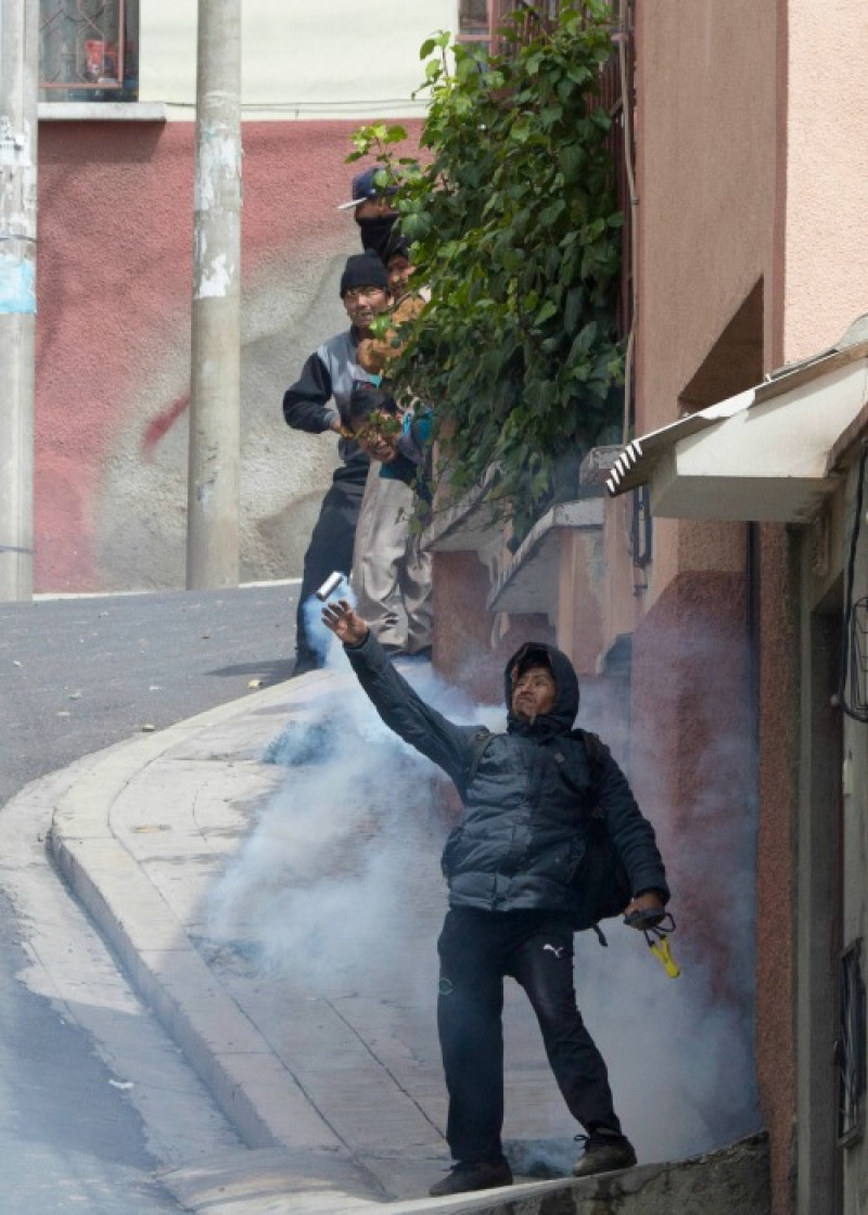 Un campesino devuelve una bomba de gas lacrimógeno disparada por la policía antidisturbios durante una protesta de agricultores de hoja de coca en La Paz, Bolivia. (AP Foto/Juan Karita)