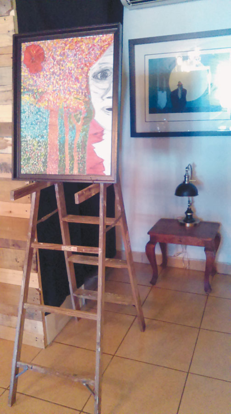 Atril. Una escalera con manchas de pintura se convierte en atril para colocar un cuadro en Café Negro.