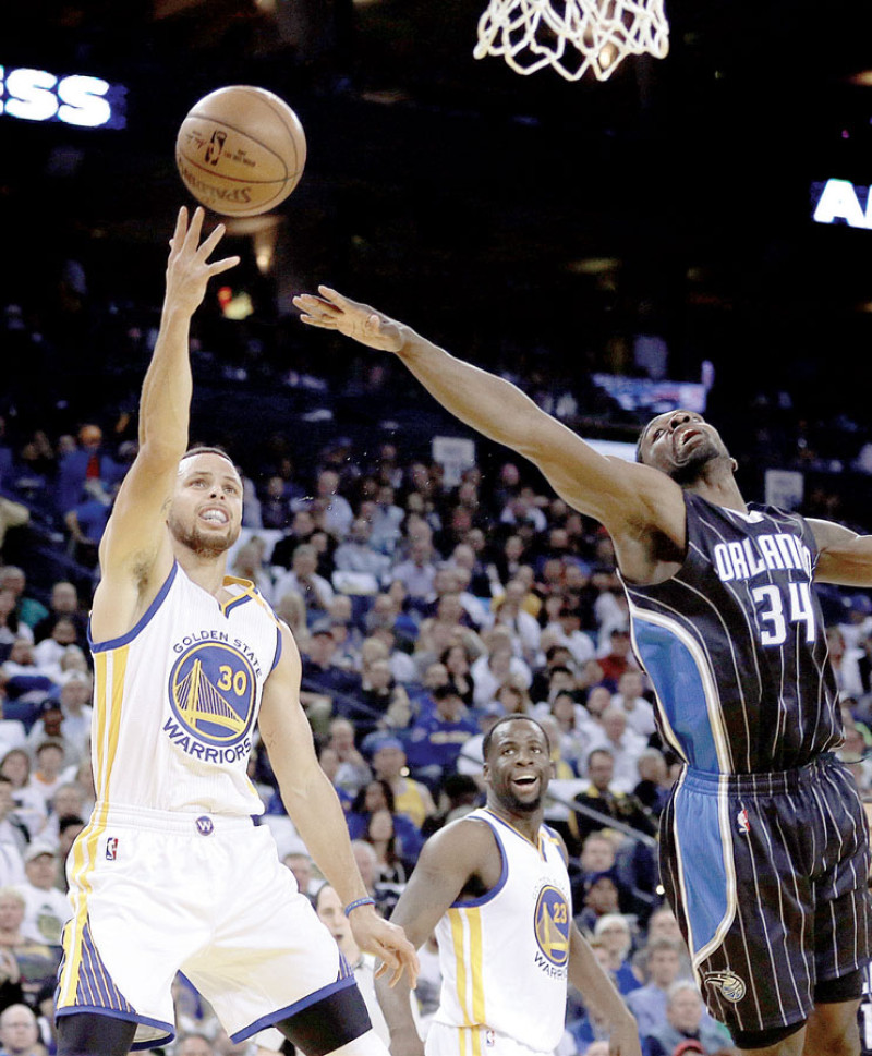Stephen Curry, de Golden State Warriors, dispara sobre Jeff Green, de Orlando Magic, durante el partido de este jueves en Oakland, California.
