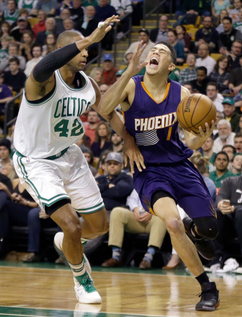 Al Horford, de los Celtics de Boston, defiende a Devin Booker, de los Suns de Phoenix, en acción del partido de anoche en el baloncesto de la NBA.