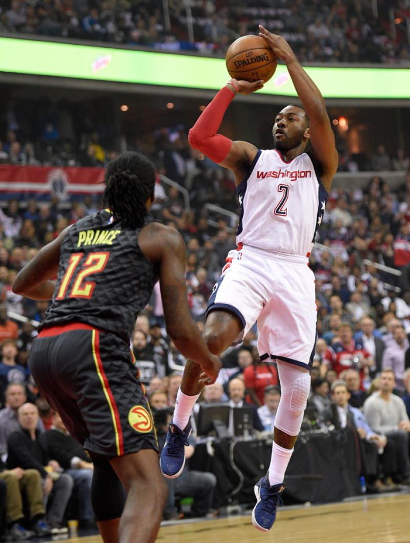 John Wall (2) de los Wizards de Washington dispara al aro sobre Taurean Prince (12) de los Hawks de Atlanta, el miércoles 19 de abril de 2017