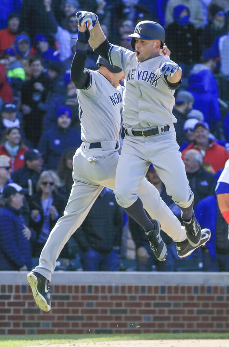 Brett Gardner, derecha, celebra con un salto junto a Jacoby Ellsbury luego de conectar su dramático cuadrangular en el noveno en el Wrigley Field, de Chicago.