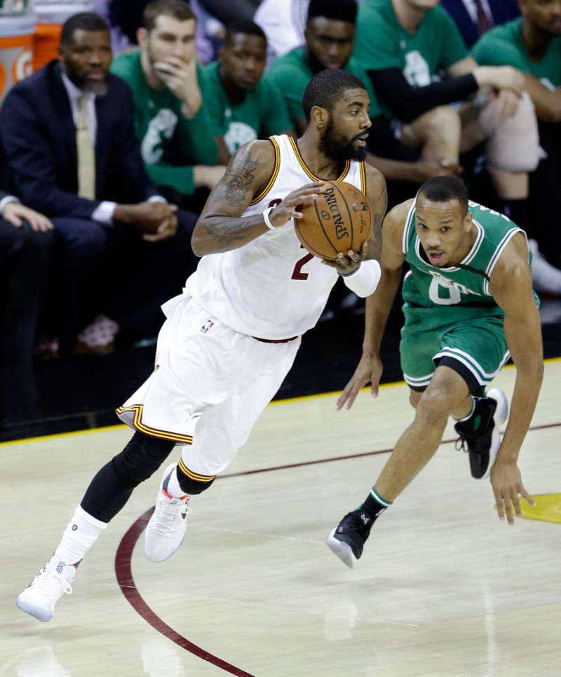 Acción. Kyrie Irving, de los Cavaliers, maneja el balón frente a la defensa de Avery Bradley, de los Celtics, en acción del partido de anoche en los playoffs de la NBA.