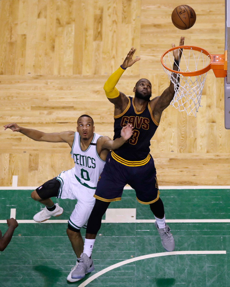 Acción. LeBron James, de los Cavaliers, busca marcar un canasto ante la defensa de Avery Bradley, de los Celtics de Boston.