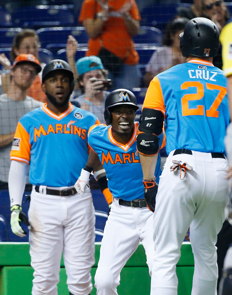 Un sonriente Dee Gordon, de los Marlins, mientras felicitaba a Giancarlo Stanton luego de dar el primero de dos jonrones anoche contra San Diego. Observa Marcell Ozuna.