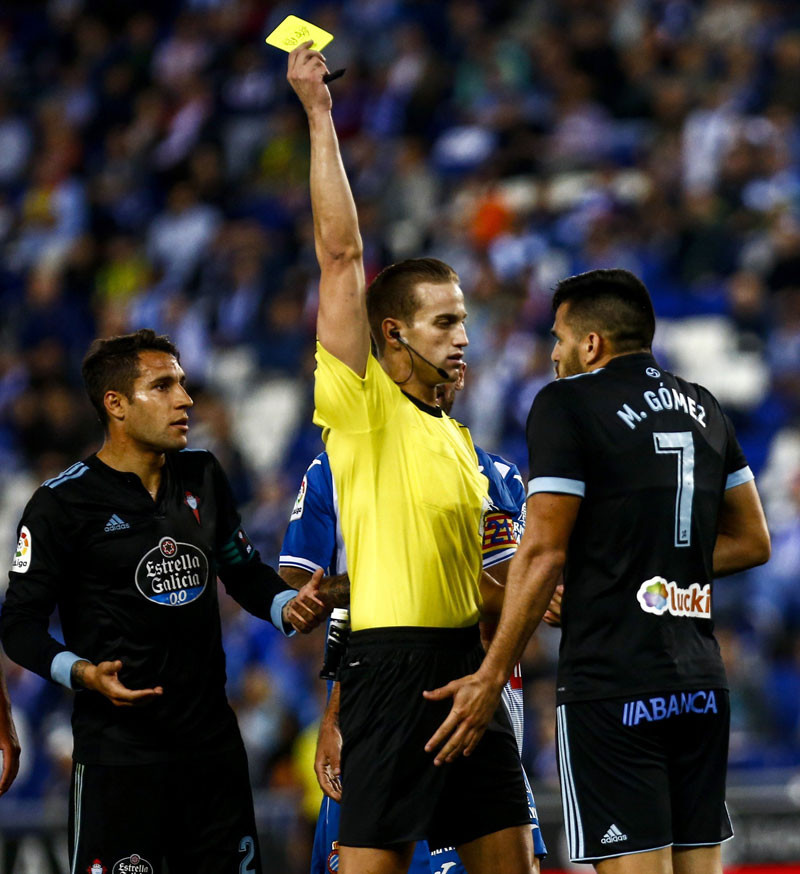 El colegiado Javier Alberola muestra tarjeta amarilla al delantero uruguayo del Celta de Vigo, Maxi Gómez.