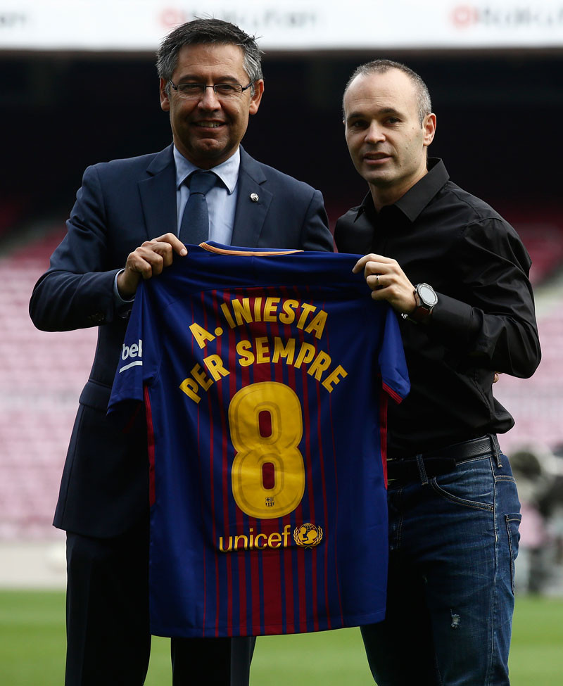 Andres Iniesta junto al presidente del FC Barcelona, Josep Maria Bartomeu, muestran la camiseta que reza: “Andres Iniesta por siempre”.
