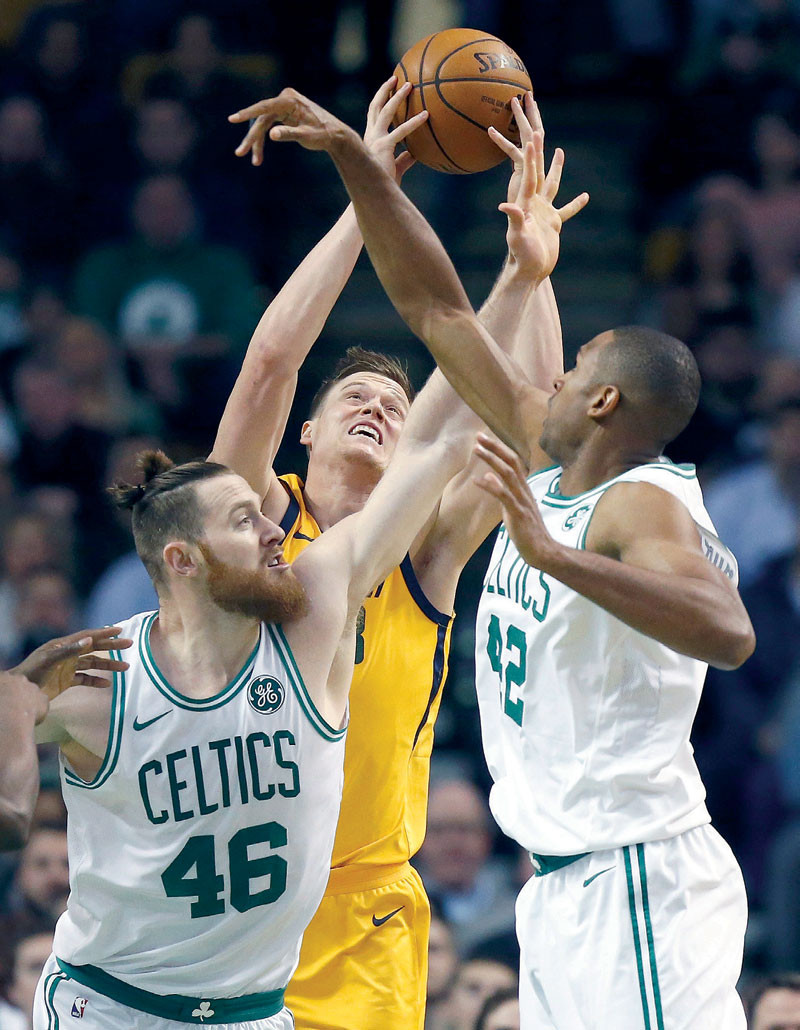 Jonas Jerebko, de los Jazz de Utah, lucha por un rebote con Aaron Baynes y Al Horford, de los Celtics de Boston, en acción del partido de anoche en el baloncesto de la NBA.