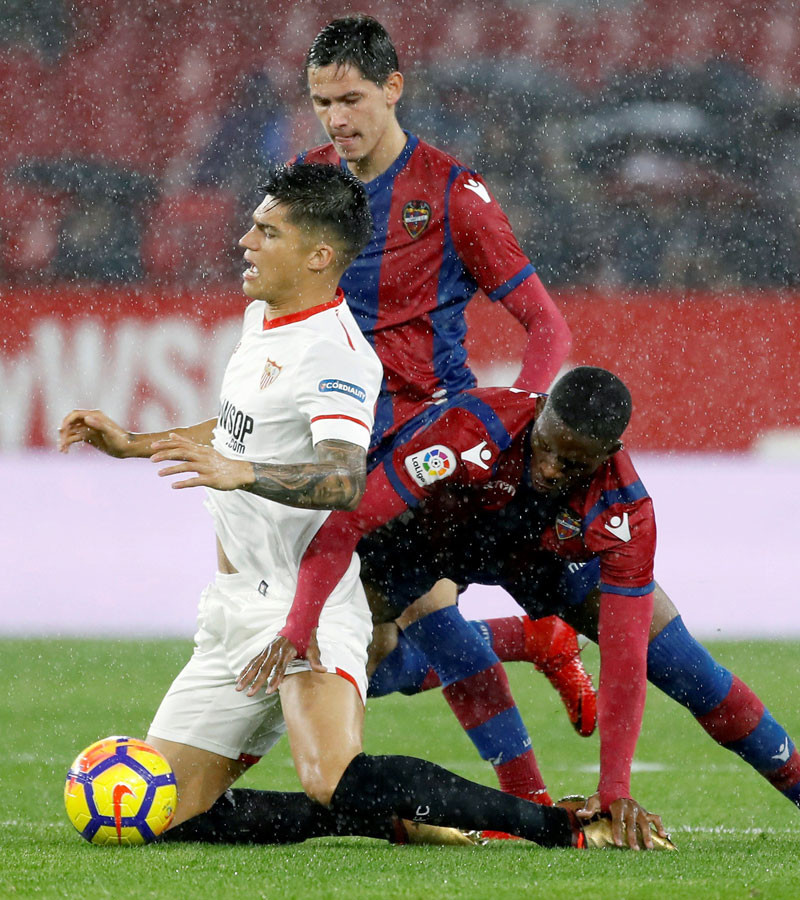 Carlos Joaquín Correa, delantero del Sevilla, y los jugadores del Levante Lerma, a la derecha y Lukic, al centro, batallan por el balón durante el partido de la decimosexta jornada de la liga de España ayer en el estadio Sánchez Pizjuán.