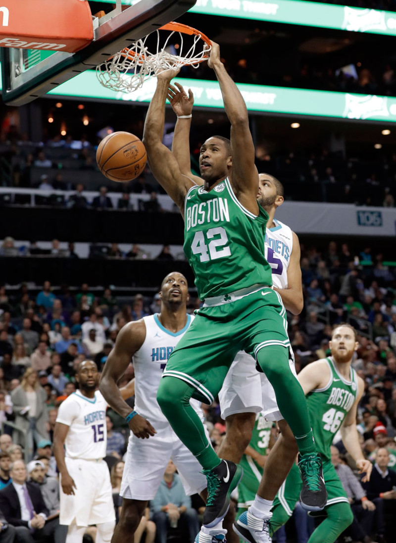 Al Horford, de los Celtics de Boston, realiza un donqueo sobre Nicolas Batum, de los Hornets de Charlotte, en acción del partido de ayer en el baloncesto de la NBA.