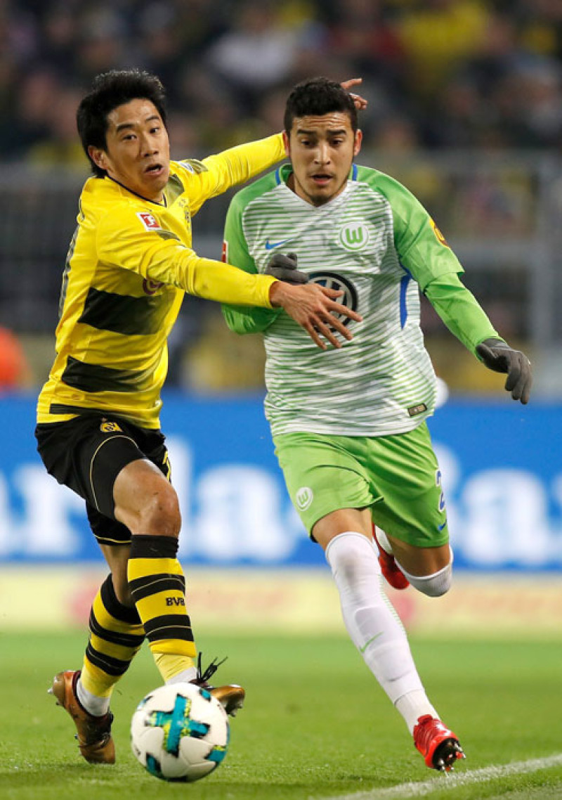 Shinji Kagawa, del Borussia Dortmund, a la izquierda, batalla por el balón con De Asevedo Furtado, del Wolfsburgo, en el partido de ayer en la Bundesliga.