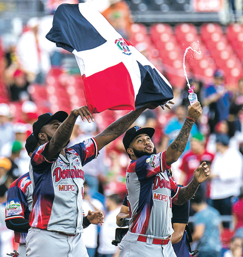 Ulises Joaquín, acompañado de Ronny Rodríguez, recorre el campo mostrando orgulloso la bandera dominicana luego del triunfo obtenido por las Águilas Cibaeña sobre los Criollos de Caguas en la Serie del Caribe.