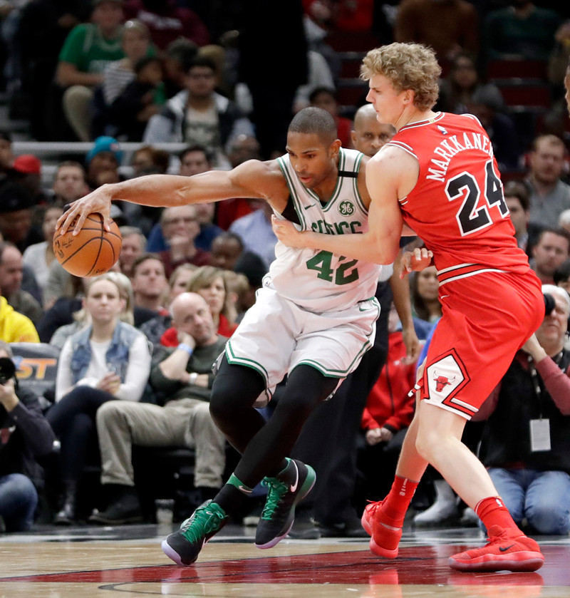 Acción. Al Horford, de los Celtics, maneja el balón ante la defensa de Lauri Markkanen, de los Bulls, en acción de la NBA anoche.