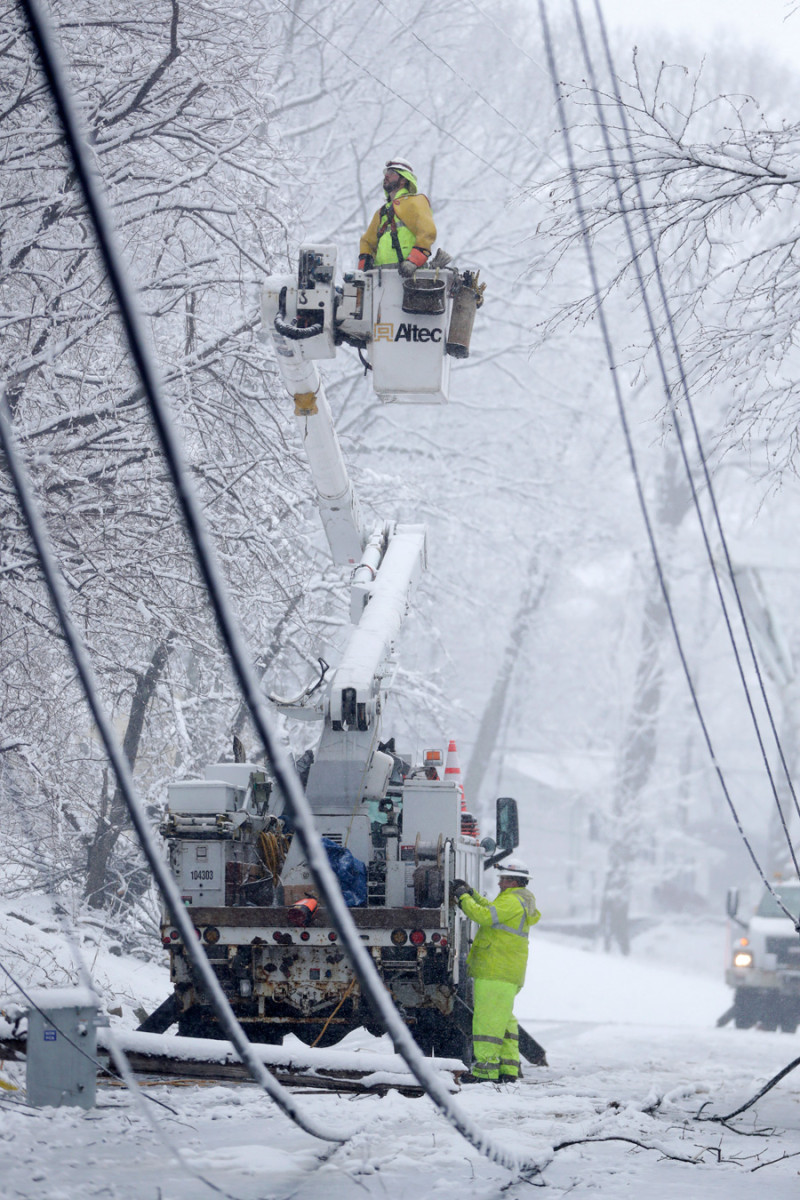 Calle. Trabajadores con un camión grúa arreglan postes caídos en Mountaininside Drive, durante la tormenta de nieve ayer en Morristown, Nueva Jersey.