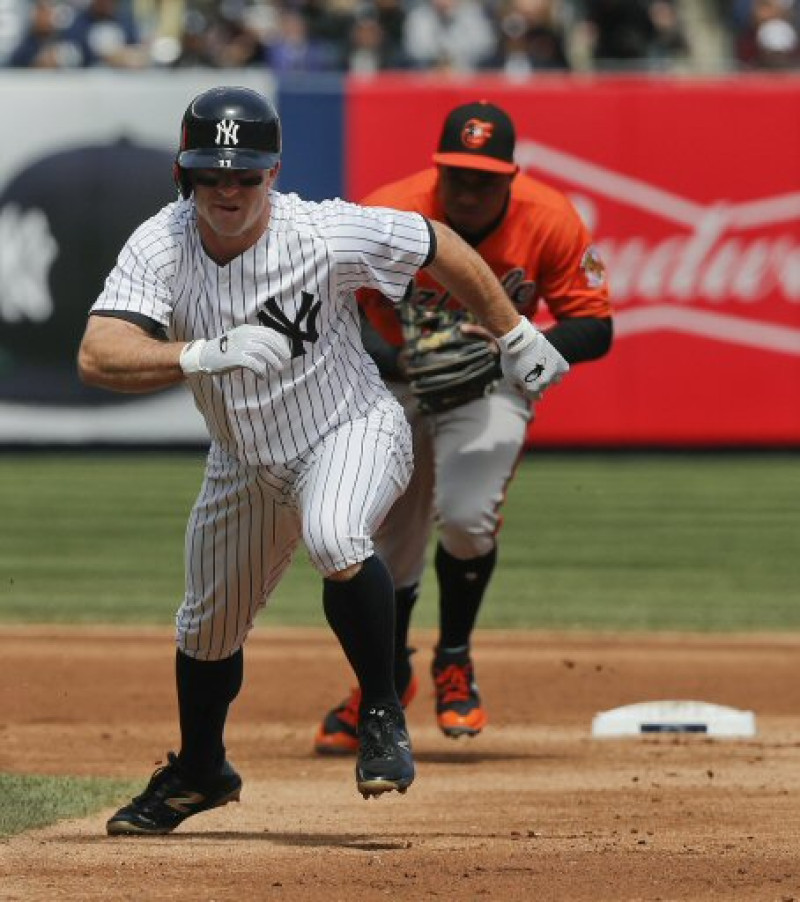 Brett Gardner, de los Yankees de Nueva York, intenta regresar a salvo a la inicial, mientras es perseguido por Jonathan Schoop, de los Orioles.