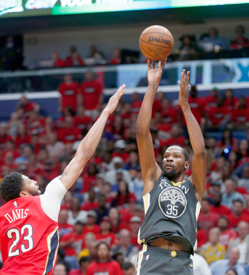 Kevin Durant, de los Warriors, hace un intento al canasto sobre la defensa de Anthony Davis, de los Pelicans, en acción de ayer en los playoffs de la NBA.