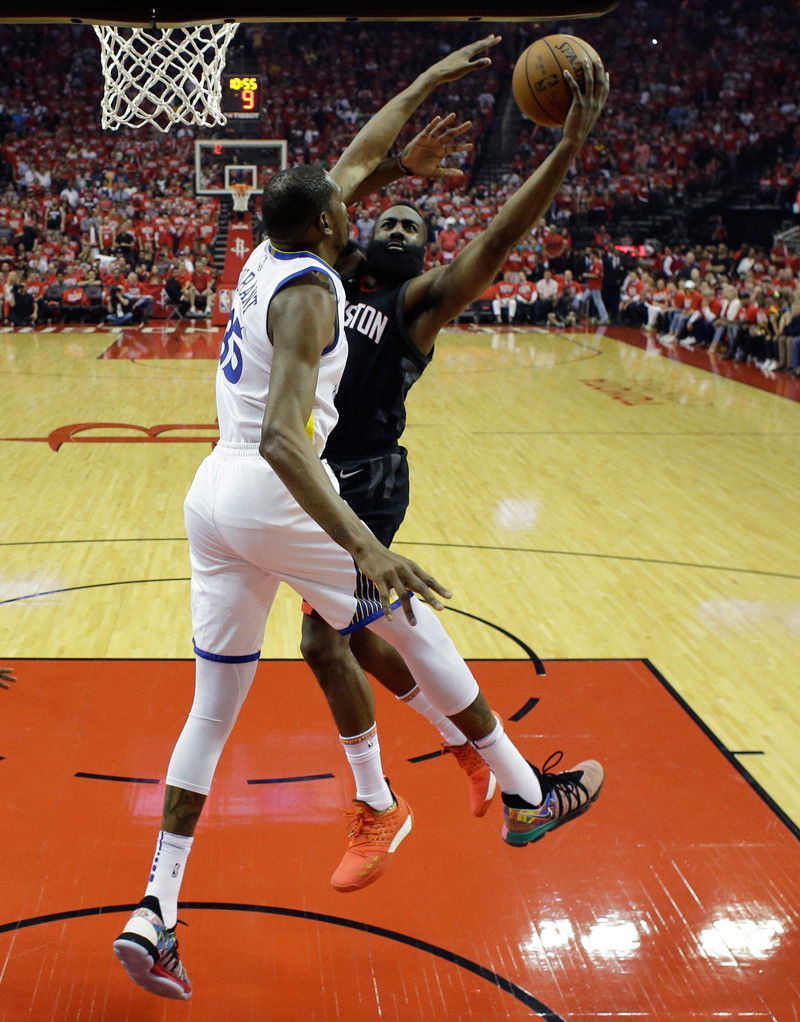 Kevin Durant, de los Warriors, bloquea un intento al canasto de James Harden, de los Rockets, en acción del partido de anoche en el baloncesto de la NBA.