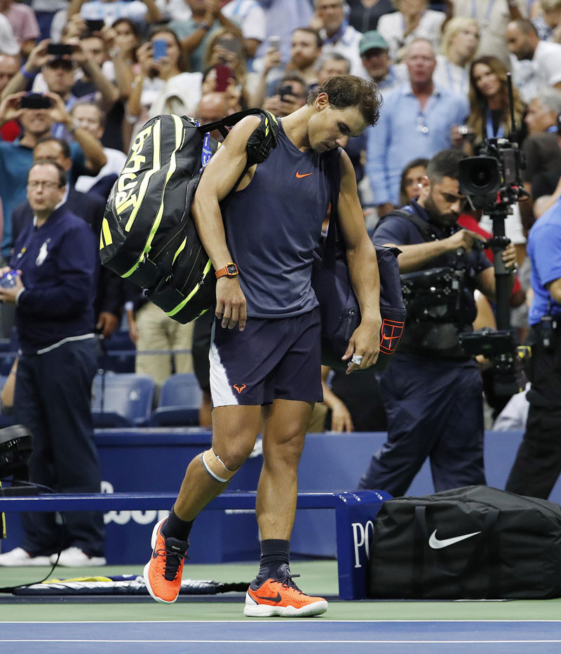 Rafael Nadal abandona cabizbajo la cancha luego de lastimarse la rodilla derecha en su enfrentamiento frente a Juan Martín del Potro en una de las semifinales