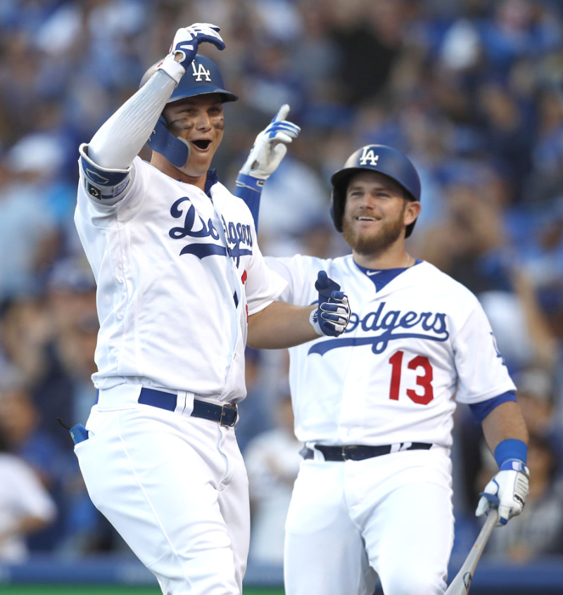 Joc Pederson y Max Muncy festejan luego que el primero conectara un jonrón abriendo el partido que antecedió a otros dos bambinazos en el éxito de los Dodgers.