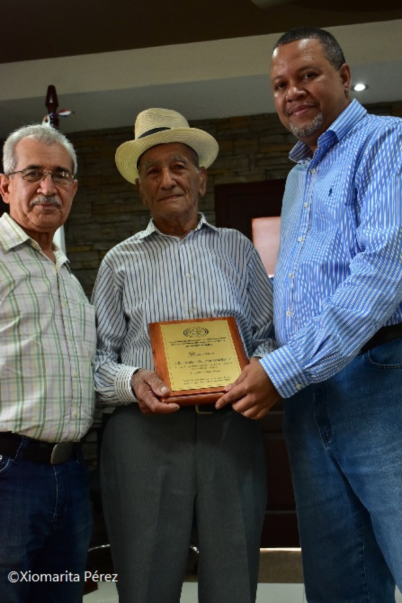 El presidente de la FSD, Bolívar Troncoso, y el presidente de la Fundación Casabe, Juan Febles, entregan a Heriberto Ortiz (don Bertico) un pergamino de reconocimiento en nombre de Fondeprosjo), como 'Portador de tradiciones'