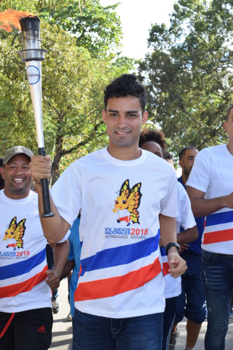 El medallista de plata olímpico Luguelín Santos en el recorrido de la antorcha de los XIV Juegos Nacionales Hermanas Mirabal por el municipio de Bayaguana.