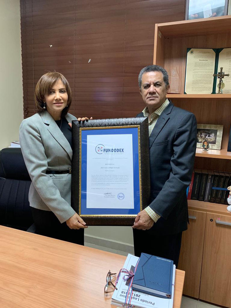La señora Adelis Olivares, presidenta de la Fundación por el Desarrollo Dominicanos en el Exterior, entrega una placa a Radhamés García, en representación de José L. Corripio.