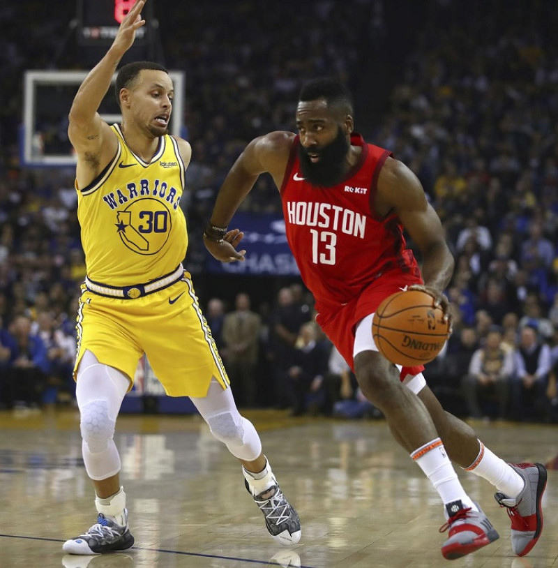 James Harden, de los Rockets, maneja la pelota ante la defensa de Stephen Curry, de los Warriors, en el partido del jueves por la noche en la NBA.
