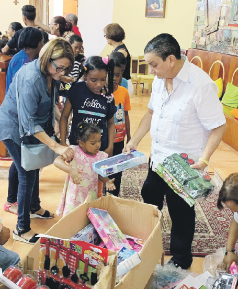 Obsequios. El empresario Rafael Almánzar Alegría entrega juguetes a niños del sector La Nueva Barquita.