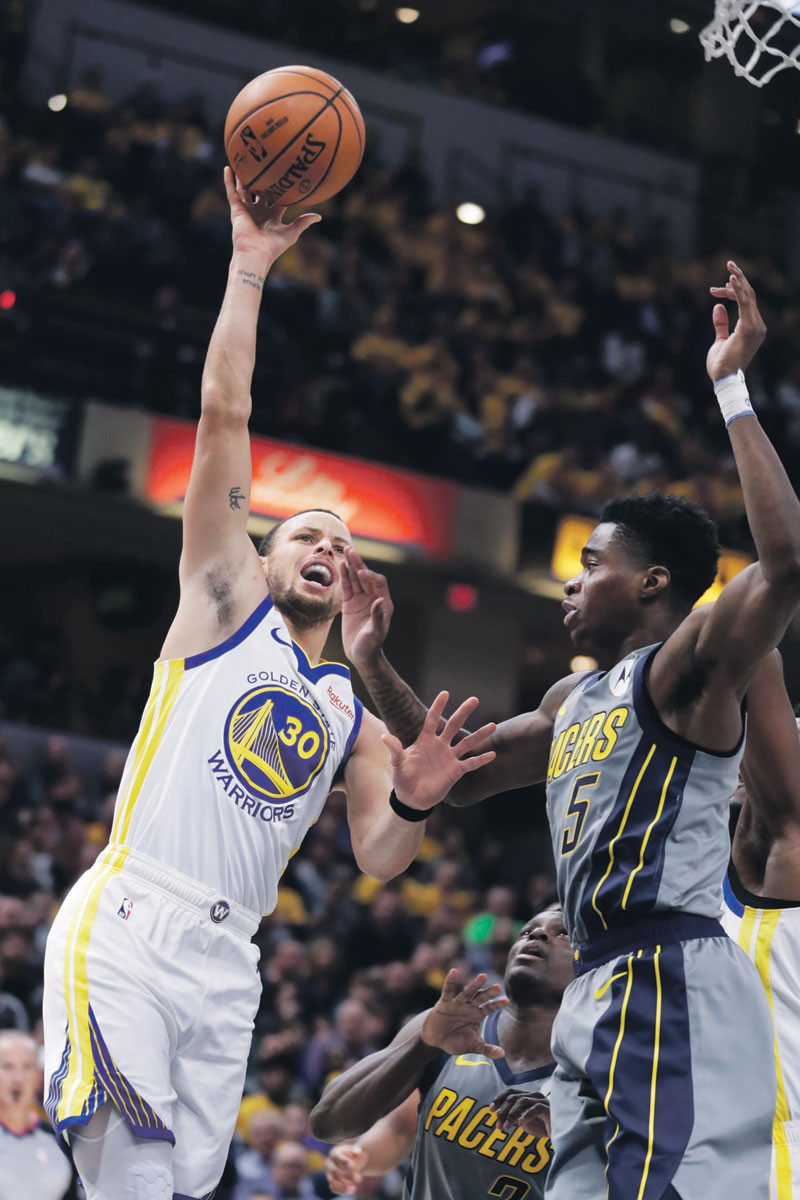 El guard de los Golden State Warriors Stephen Curry realiza un disparo al aro ante la defensa Edmond Sumner, de Indiana Pacers, durante el partido realizado en Indianapolis.