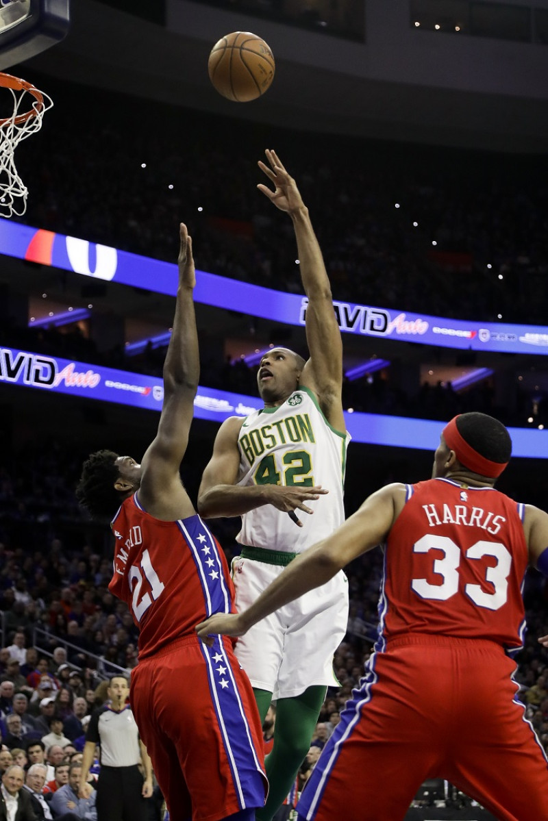 Al Horford, de los Celtics, realiza un intento al canasto sobre la defensa de Joel Embiid, de los Sixers, en acción del partido del martes por la noche en la NBA.