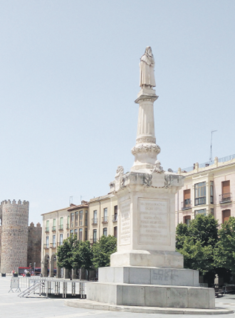 En primer plano el monumento a Santa Teresa; al fondo, la Puerta del Alcázar, en la Plaza del Mercado Grande, Ávila. CARMENCHU BRUSÍLOFF