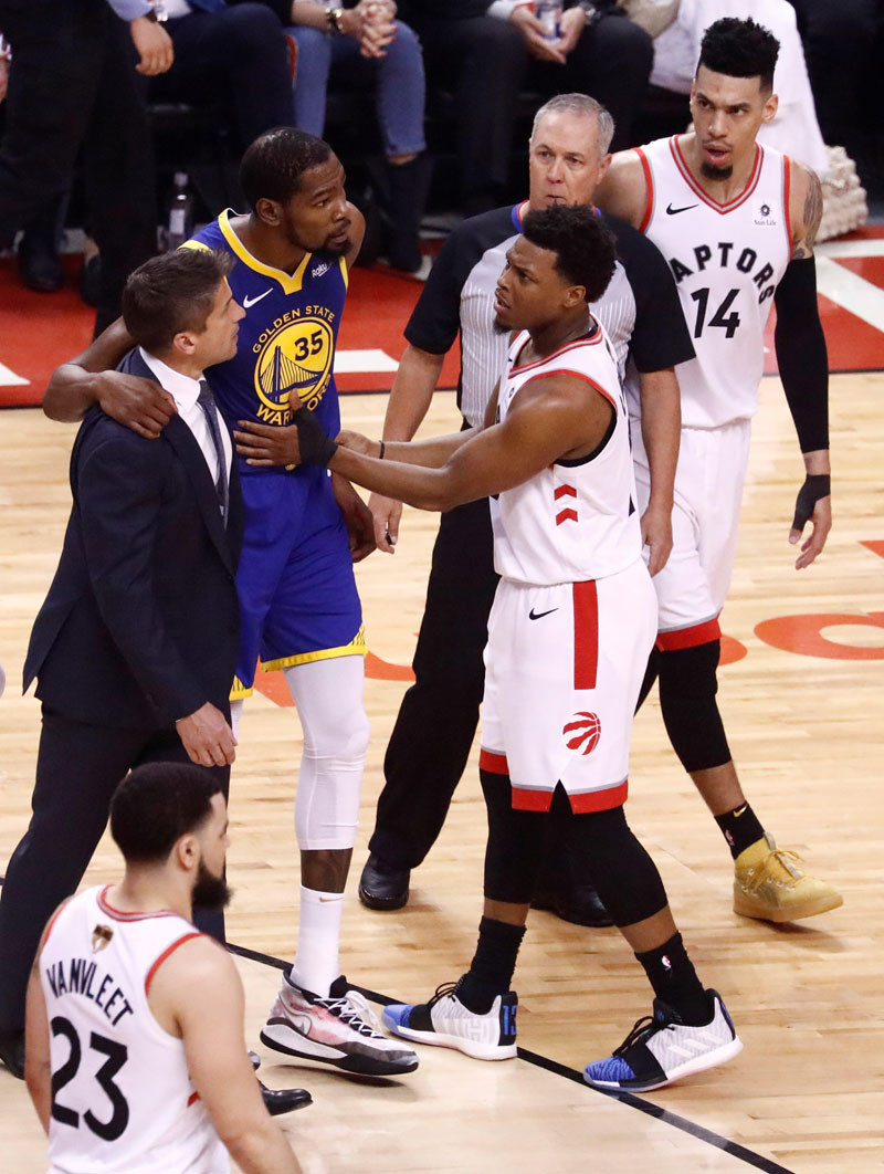 Kevin Durant sale de la cancha con la ayuda de un entrenador en el juego de baloncesto de las finales de la NBA entre los Warriors y los Toronto Raptors. EFE