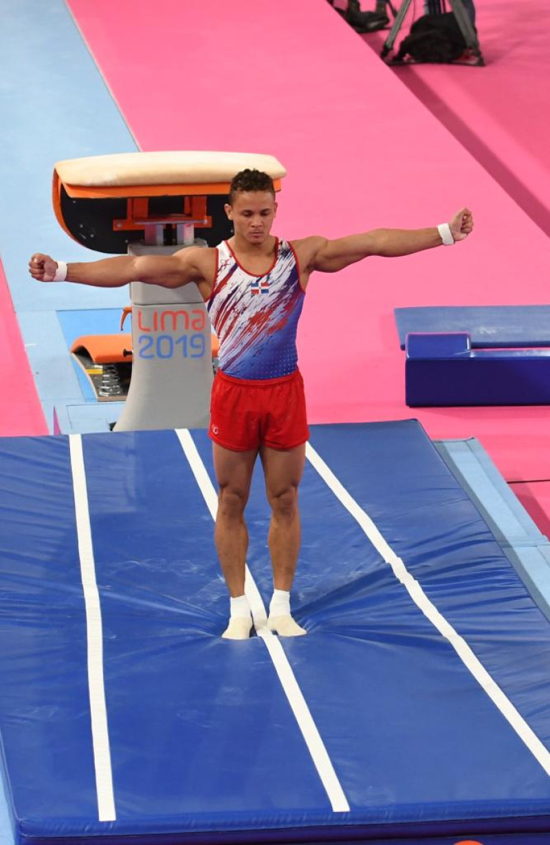 El dominicano Audrys Nin levanga sus brazos luego de ejecutar su espectacular salto que le validó la medalla de oro en el evento de salto al caballo en gimnasia artística.