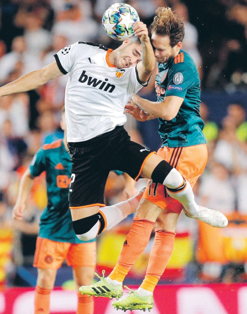 El delantero del Valencia, Maxi Gomez, y el defensa del AFC Ajax, Daley Blind, durante el partido de la segunda jornada de Liga de Campeones. /EFE