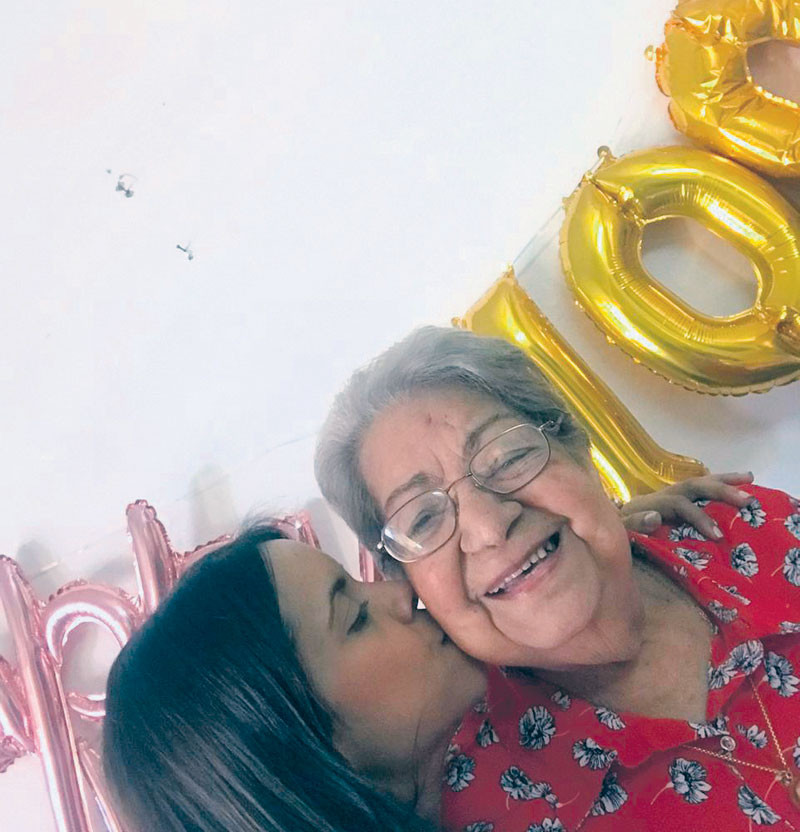 Doña Luz María Durán sonríe al recibir un beso de una nieta. CORTESÍA DE LA FAMILIA/LISTÍN DIARIO.