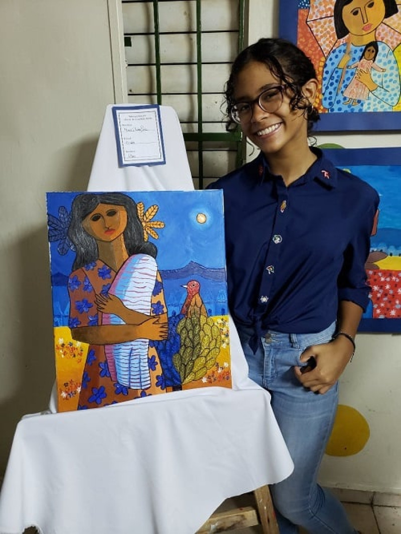 María Isabel Núnez junto a una de sus pinturas en la exposición de arte.
