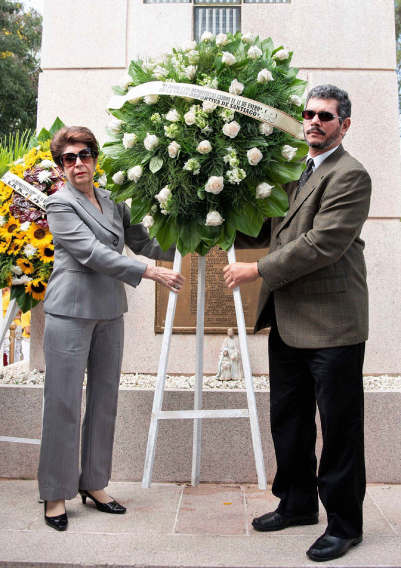 Julia Lora Hiernimus y Enmanuel García Musa depositan una ofrenda floral en el mausoleo donde reposan los restos de los deportistas.