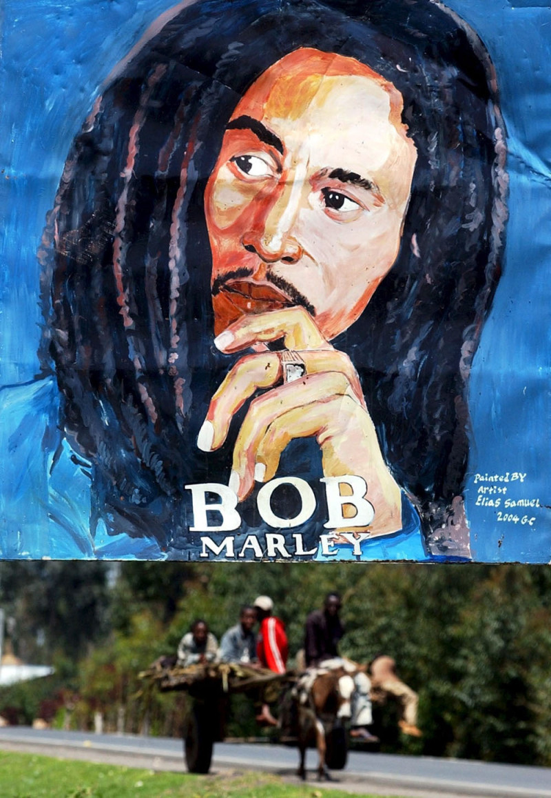 Varias personas pasan junto a un cartel con el retrato de Bob Marley en Adis Abeba. EFE/Stephe Morrison.