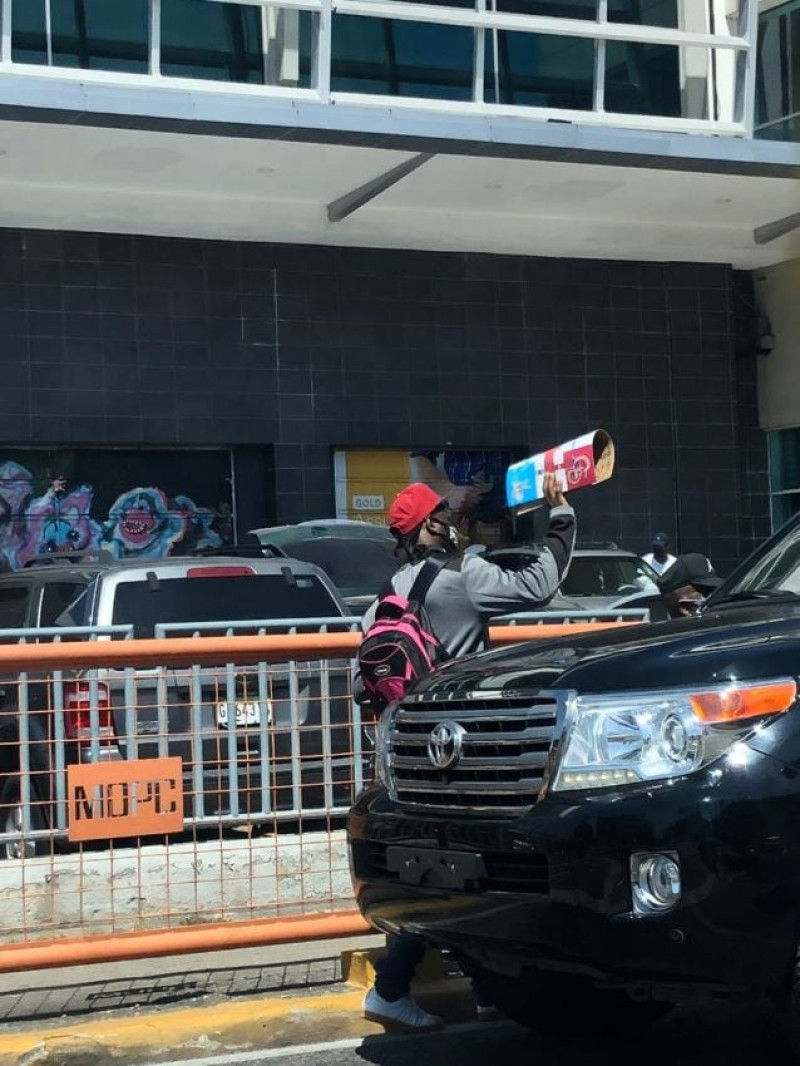 Un vendedor de parchís muestra a un conductor ese artículo para que el mismo le sea comprado, en la avenida Abraham Lincoln con 27 de febrero. Foto: Maricely Pujols.
