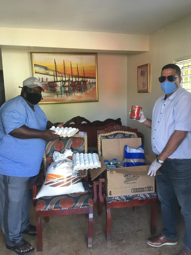 Francisco José Fernández, tesorero de la Federación Dominicana de Voleibol, al momento de hacer entrega de alimentos a Ramón Egalite, titular de la Asociación de Bonao.