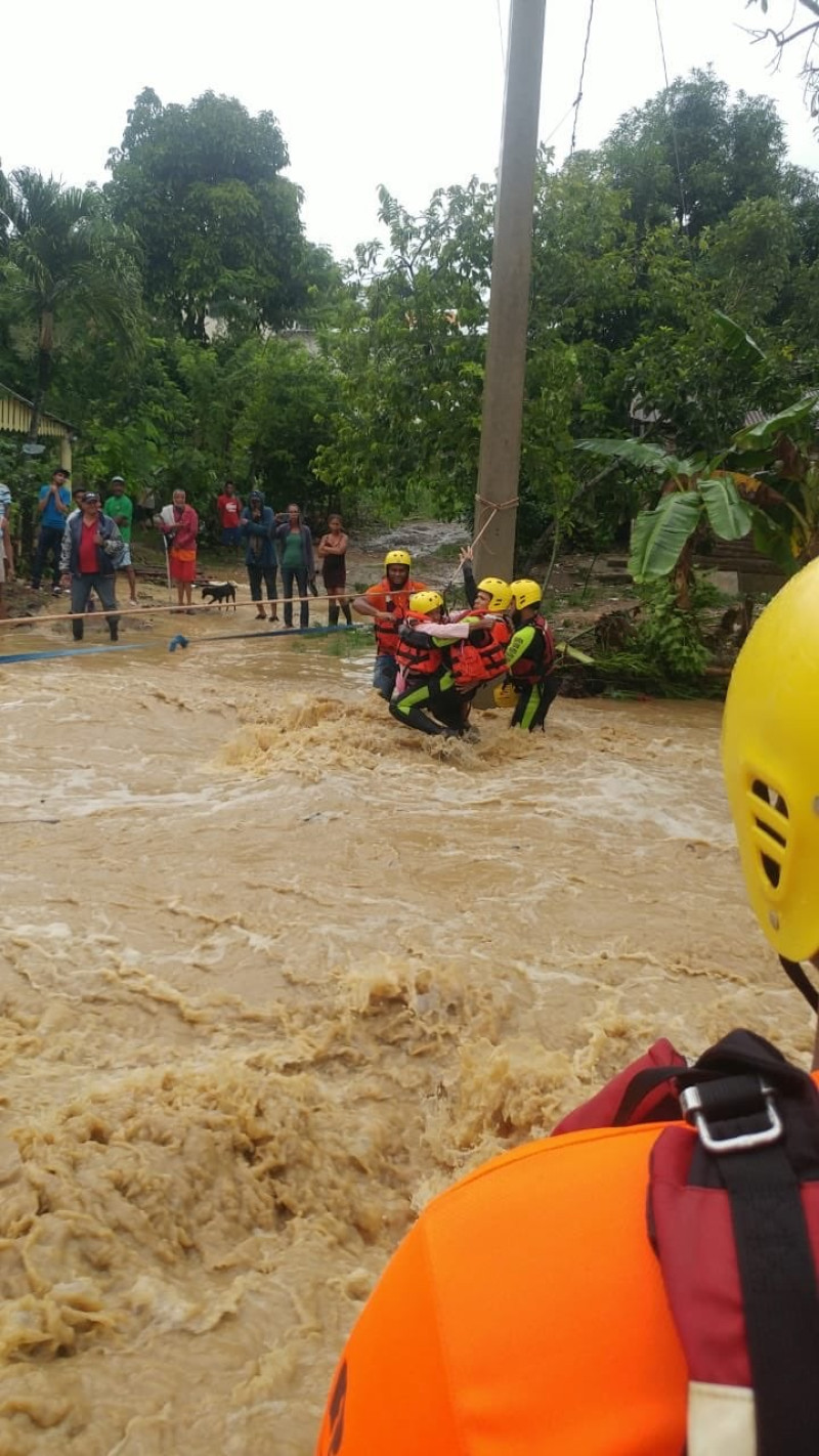 Miembros de la Denfensa Civil trasladan a personas afectadas por las inundaciones provocadas por Isaias en la provincia Duarte.
