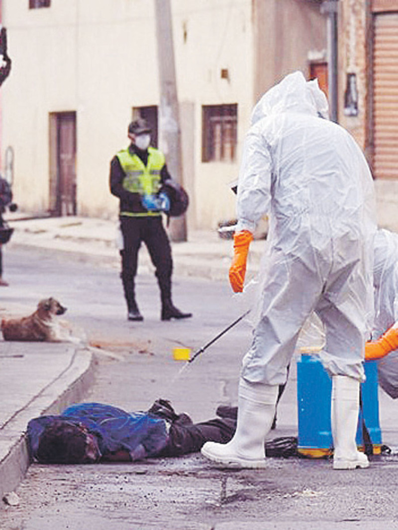 Obreros desinfectan un cuerpo en Cochabamba. AP