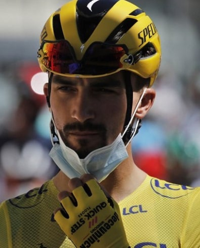El francés Julian Alaphilippe, con el maillot amarillo de líder de la clasificación general, se ajusta la mascarilla al inicio de la quinta etapa del Tour de Francia, (AP)