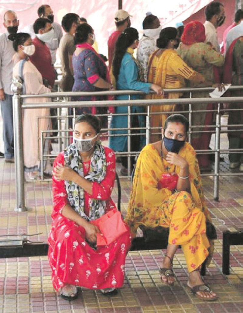 Dos mujeres esperan por servicios en India. AP