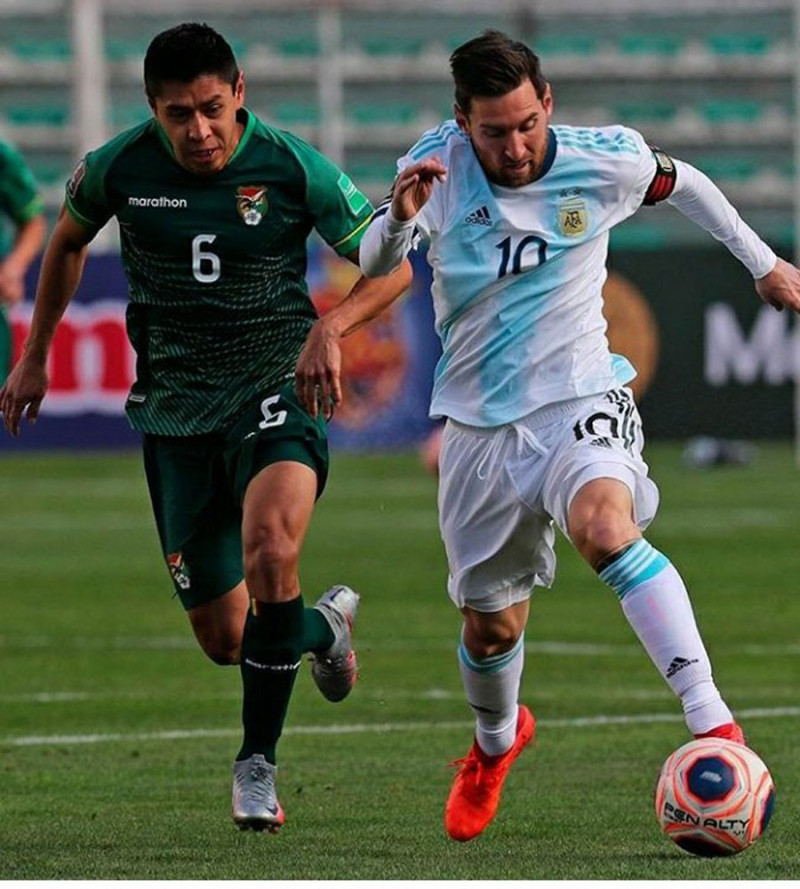 Lionel Messi se desplanza ante la cerrada defensa de un integrante de la selección de Bolivia.