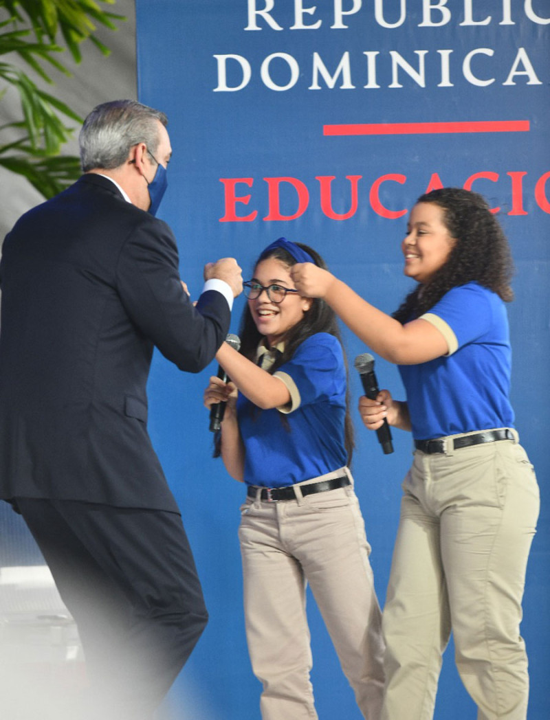 El presidente Luis Abinader saluda con un choque de puños a dos estudiantes, como parte del distanciamiento físico por el Covid-19, durante el acto de apertura ayer del año escolar a distancia. /P. 4-5 VÍCTOR RAMÍREZ/LISTÍN DIARIO