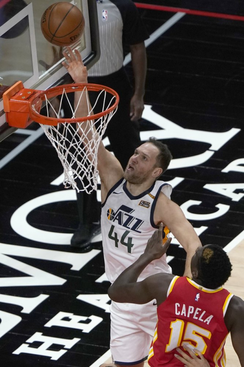 El alero de los Utah Jazz, Bojan Bogdanovic (44), lanza una canasta mientras el pívot de los Atlanta Hawks, Clint Capela (15), defiende en la primera mitad de un juego de baloncesto de la NBA este jueves en Atlanta.