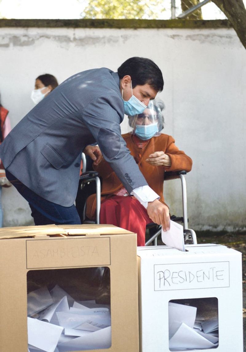 El izquierdista Andrés Arauz ayuda a votar a su madre. / AFP