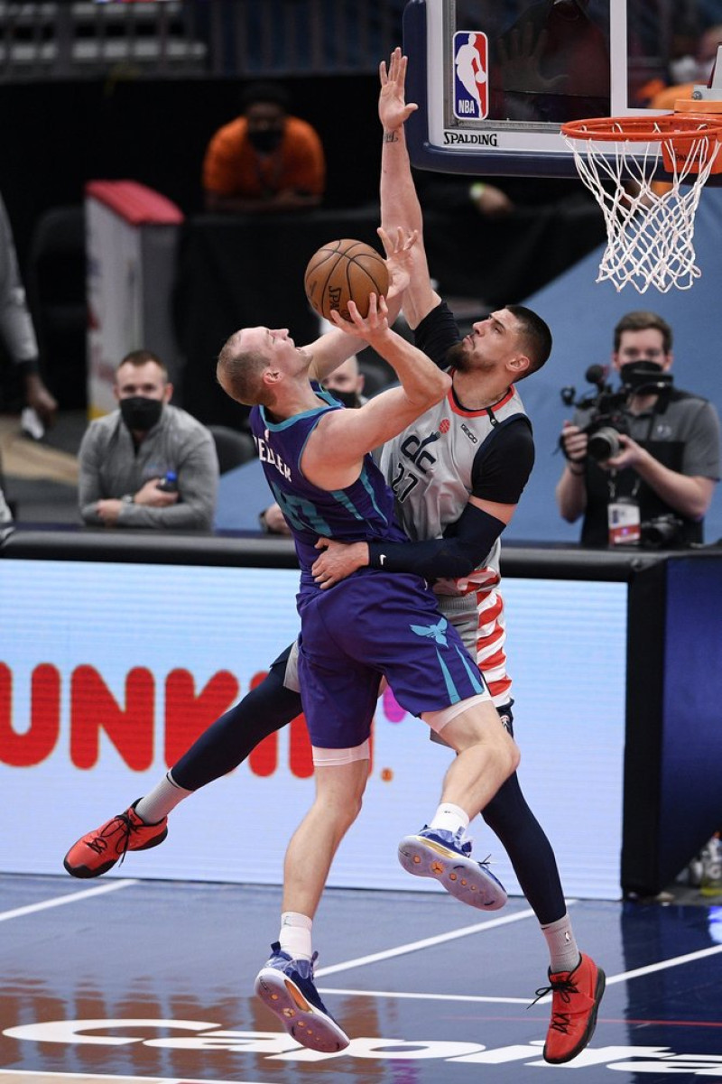El pívot de los Charlotte Hornets, Cody Zeller, a la izquierda, va a la canasta contra el pívot de los Washington Wizards, Alex Len, a la derecha, durante la primera mitad de un partido de baloncesto de la NBA, este martes en Washington.