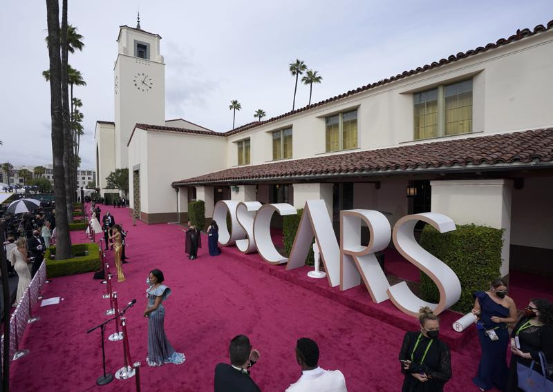 Maria Bakalova, de izquierda a derecha, Andra Day y Regina King son entrevistadas mientras Marlee Matlin camina por la alfombra roja de los Oscar el 25 de abril de 2021 en Union Station en Los Angeles. (Foto AP/Mark Terrill, Pool)